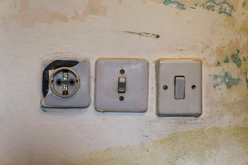 Vintage broken european power outlet on abstract textured wall