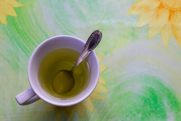 Hot tea cup on a colorful table background