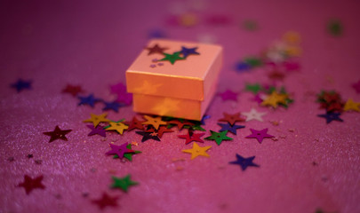 gift box with glitter on it on pinky background