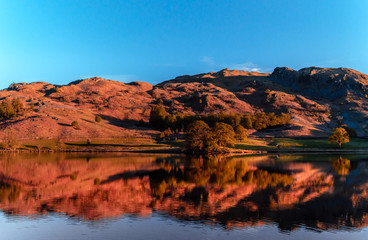Fototapeta na wymiar Rydal water lake in the Lake District, Cumbria, UK. Autumn reflections in the clear and still waters.