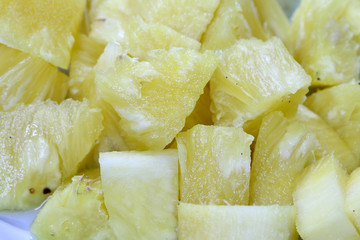 Close up slice pineapple background texture in white dish. Slide and piece of fresh fruit.