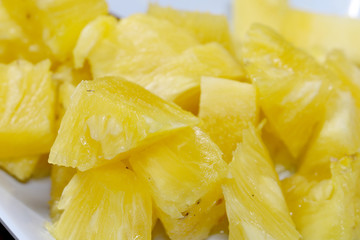 Close up slice pineapple background texture in white dish. Slide and piece of fresh fruit.