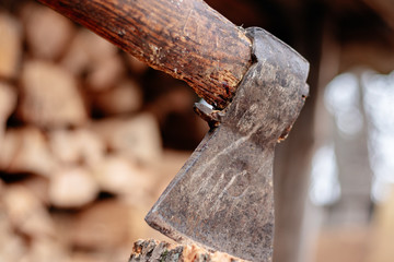 An ax stuck in a log. Ax blade close.