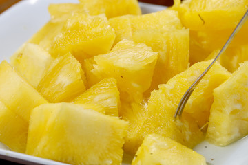 Close up slice pineapple background texture in white dish. Slide and piece of fresh fruit.