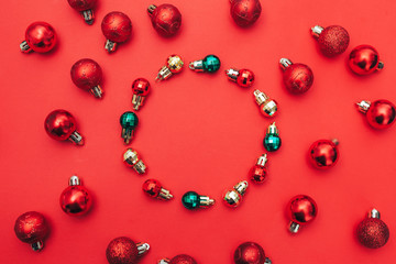 christmas composition. round frame made of red christmas balls on red background. Copy space for text in centre. flat lay