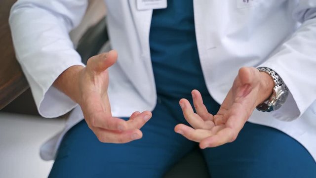 Doctor using hand sign while talking. Cropped view of doctor gesturing while talking in office