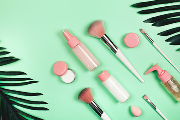 Care cosmetics in bottles on a delicate green background.