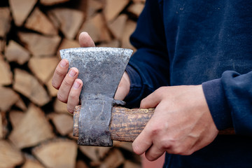 A man checks an ax blade. Holds an ax in his hands. Close up