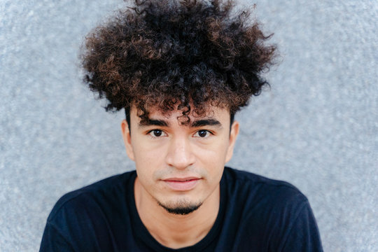 From Above Of Ethnic Male With Afro Hairdo In Black T Shirt Looking At Camera On Blurred Background