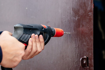 Hands of a man drills with an electric drill