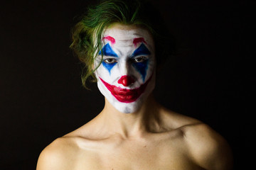 Portrait of a man with clown makeup and green hair. Cosplay.