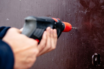 Hands of a man drills with an electric drill