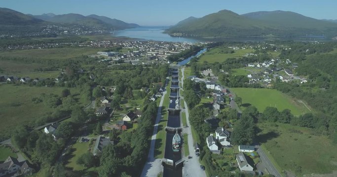 Wide aerial travelling down the Neptune's Staircase series of locks on the Caledonian Canal in Banavie towards Loch Eil, Fort William, Scotland