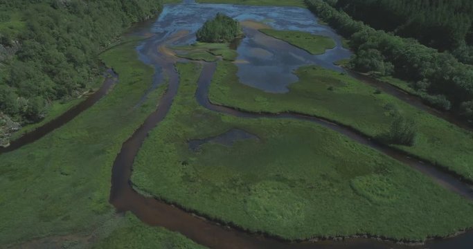 Rising top-down aerial over river tributaries, marshy grasslands and glens of Loch Dochart in the Scottish Highlands