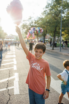 Cheerful kids enjoying sweet candyfloss on street