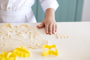 close up of boy hands baking cookies in kitchen