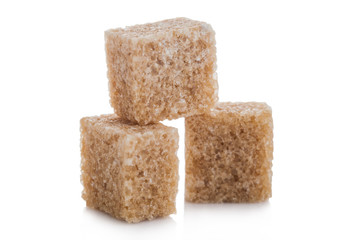 Close-Up shot of natural brown sugar cubes on white background.
