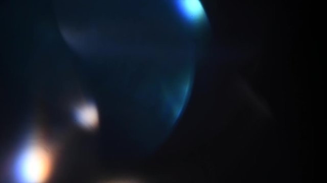 Lens Flare, Abstract Bokeh Lights Moving. Leaking Reflection of a Glass, Crystal, Defocused Shining Colorful rainbow Light Leaks, Rays on Black Background. 4K UHD video, slow motion