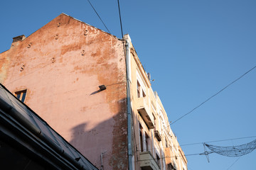 Summer photo, old houses with peeling paint, blue sky on the background