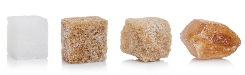 Cubes of natural brown and white and caramelized unrefined sugar cubes on white background. macro
