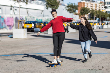 Two teens having fun with a skateboard