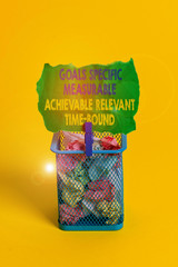 Obraz premium Word writing text Goals Specif Measureable AC. Business photo showcasing Goals Specific Measurable Achievable Relevant Time Bound Trash bin crumpled paper clothespin empty reminder office supplies