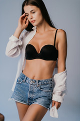 Sexy body women wear denim shorts and black lingerie dark grey background studio indoor