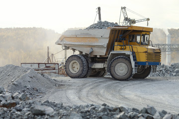 Heavy mining truck loaded with stone ore in a mining enterprise.