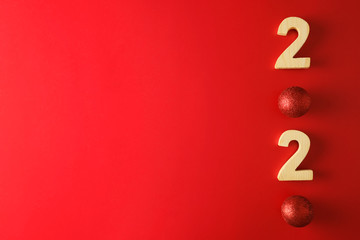 New year 2020 decor with red ball and wooden number flat lay on red background