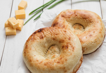 Bread and Bakery. Uzbek cuisine. The typical traditional uzbek round shape bread and green onion, olives and cheese on white background.