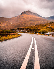 Road in the mountains in the Isle Of Skye, Scotland. Dramatic autumn and moody day on a scenic road trip.