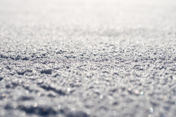 Macro shot of pure white snow with shallow depth of field and pleasant blurry bokeh. Great winter christmas background for your layout