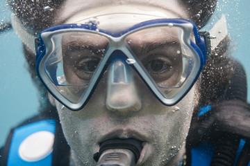 primer plano de la cara de un buceador dentro del mar haciendo burbujas mientras respira. buceo...