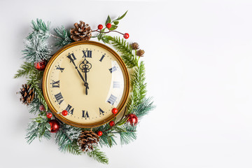 Fototapeta na wymiar Twelve o'clock, like New Year's Eve. Gold vintage clock in a Christmas decor on a white background. Copy space. New year art