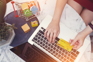 Online shopping concepts, woman hands using credit card and laptop computer for online shop, money transfering and payments transaction at home, lifestyle