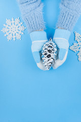 Children's hands in woolen mittens on a blue background. Winter concept. Christmas concept. Close-up copy space