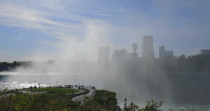 Majestic view of Niagara Falls mist with Canadian city skyline in the background