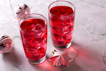 Glass of mango dragonfruit refresher drink on marble table with ice cubes. Copy space.