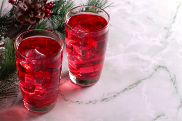 Glass of mango dragonfruit refresher drink on marble table with ice cubes. Copy space.