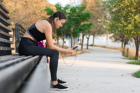 Young woman is looking her smartphone while she is sitting