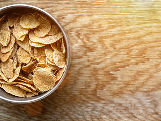 whole grain corn flakes close-up in bowl on wooden background with copy space, useful breakfast Wholemeal Cornflakes