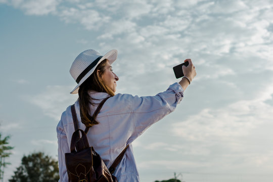 Young woman is taking a self portrait with her smartphone. Travel, lifestyle