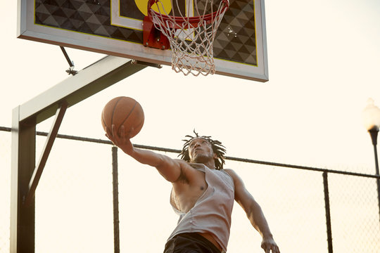 African-American man playing basketball outdoors
