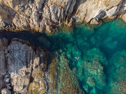 Aerial view of a person swimming in a tropical lagoon