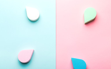 Beauty, make up sponges or beauty blenders in pastel colors on two color background, copy space, top view. Beauty background