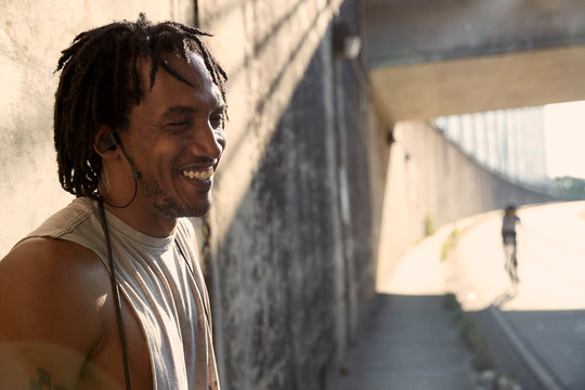 African-American man laughing wearing earbuds
