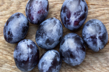 fresh organic plums on wooden background