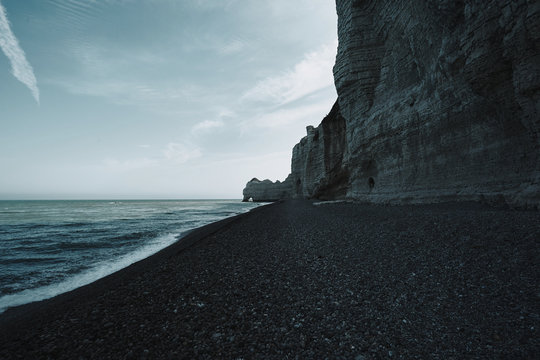 Pebble seashore with huge rocks in Etretat, Normandy