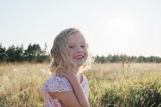 portrait of a young girl smiling with a sparkly dress at sunset