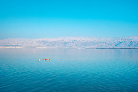 Man floating in the Dead Sea in early morning, Ein Bokek, Israel